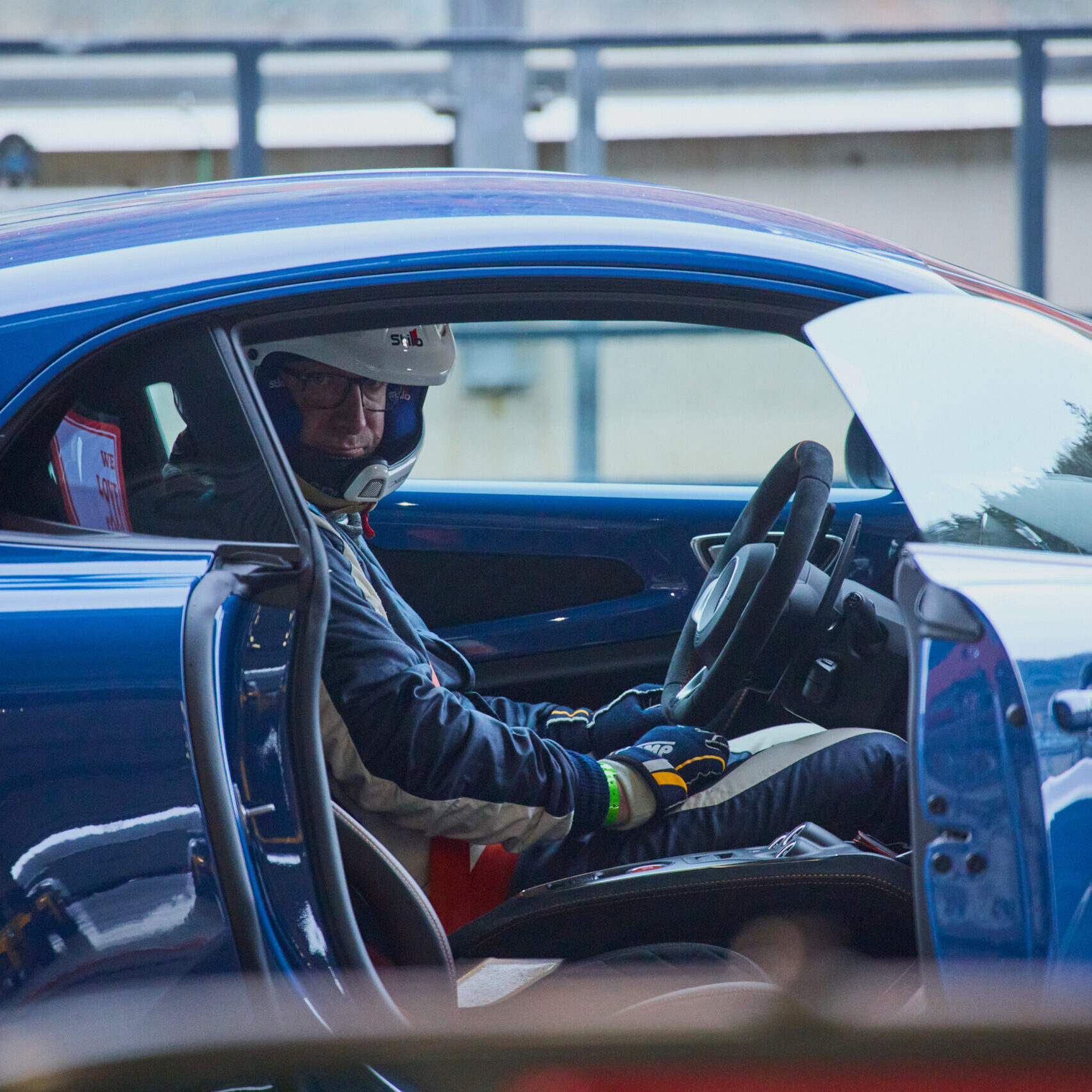 Alpine A110 en attente de son passager sur circuit illustrant le choix entre trackday et stage de pilotage