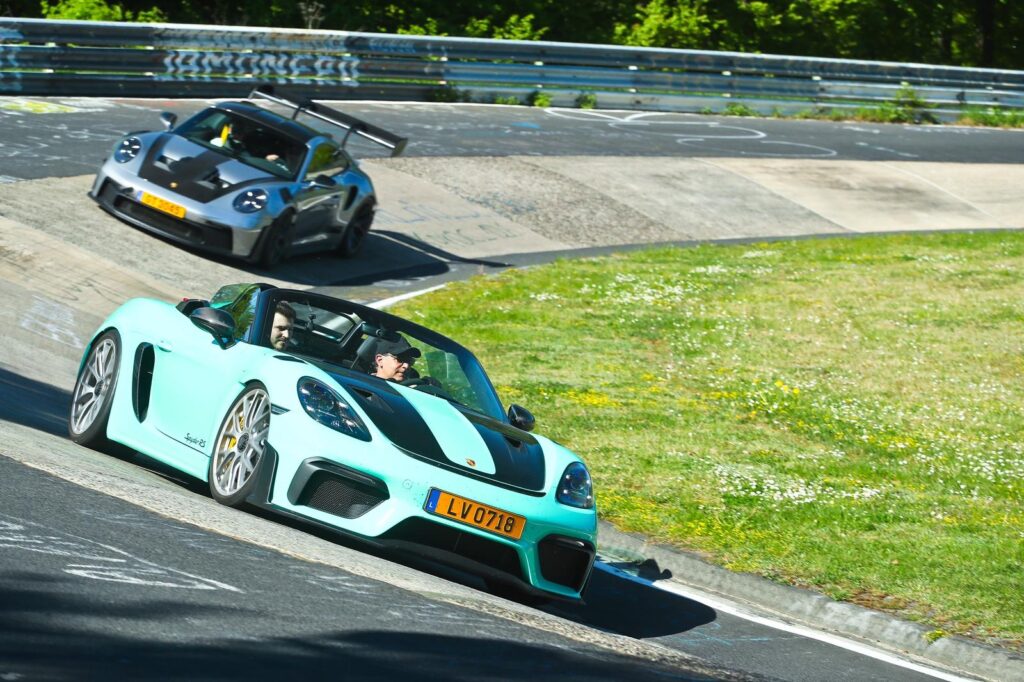 Porsche 718 Spyder RS bleu ciel et GT3 RS en virage sur le circuit du Nürburgring Nordschleife